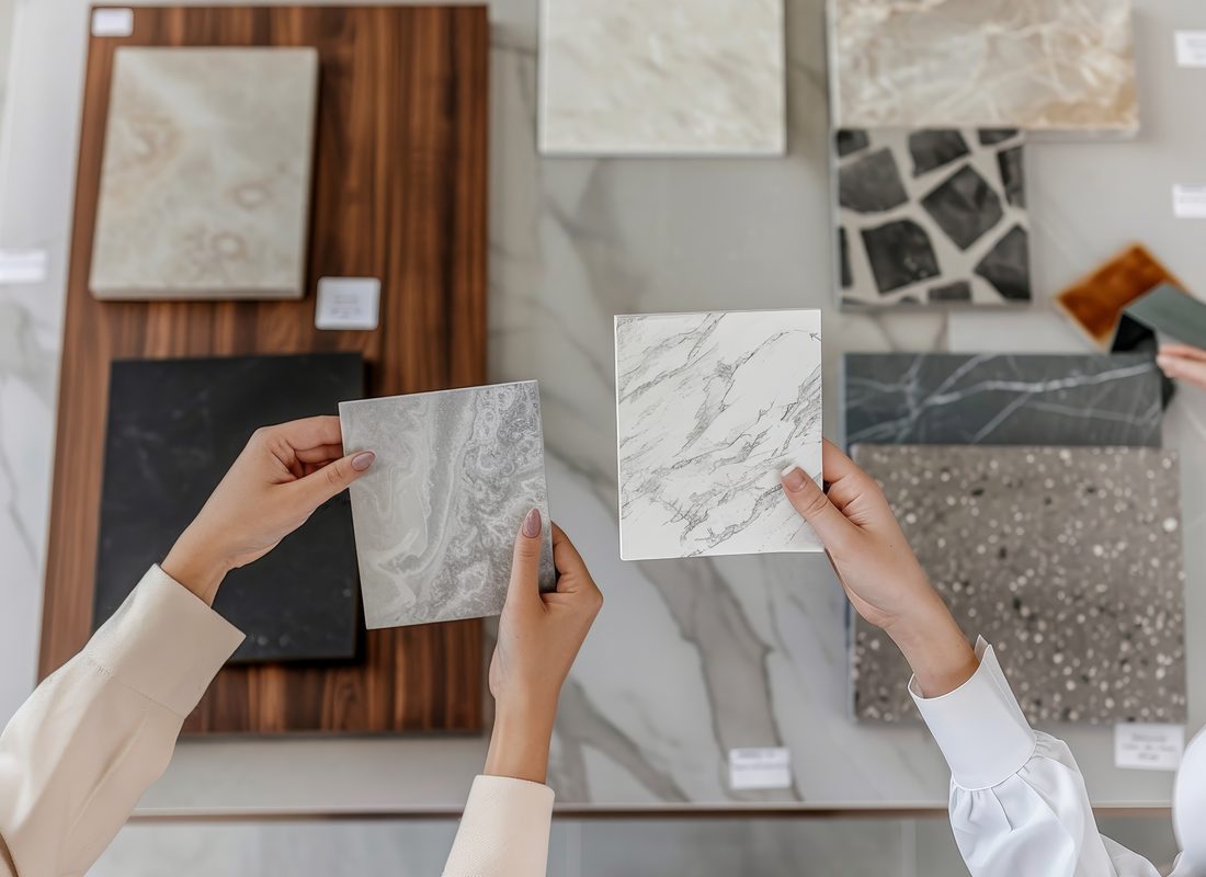 Two people comparing marble and terrazzo countertop samples on a table